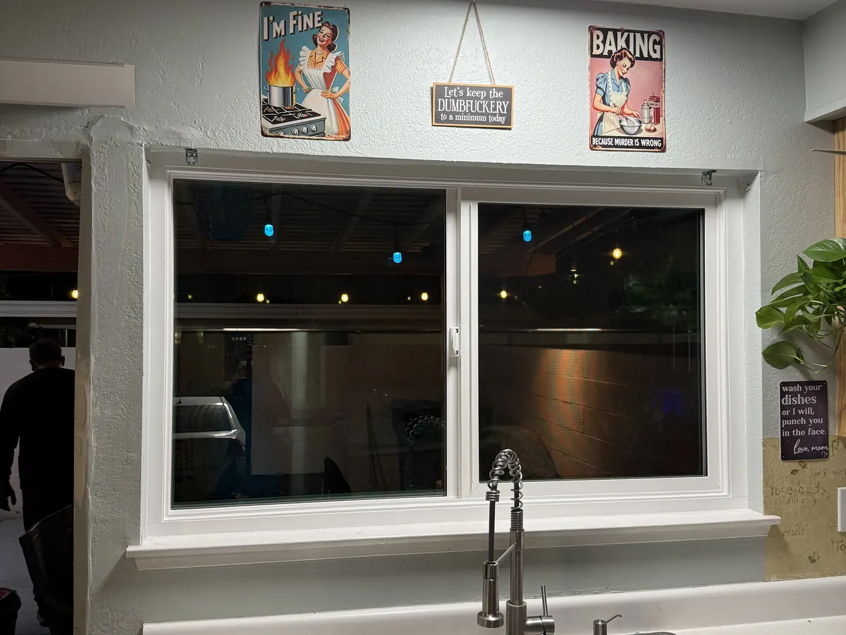 White sliding window above a kitchen sink, seen from inside.